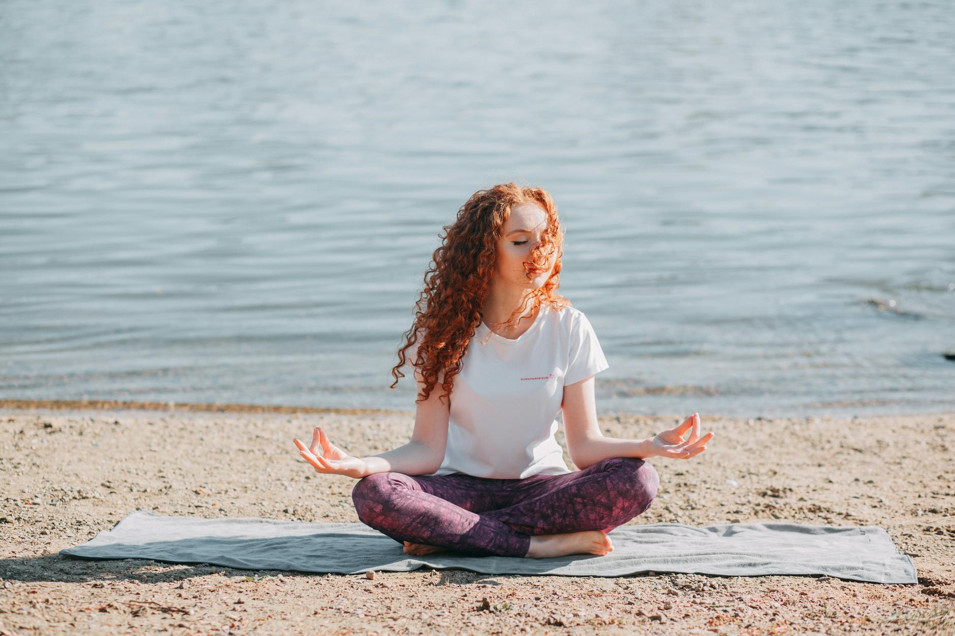 woman doing yoga exercise at the sea shore