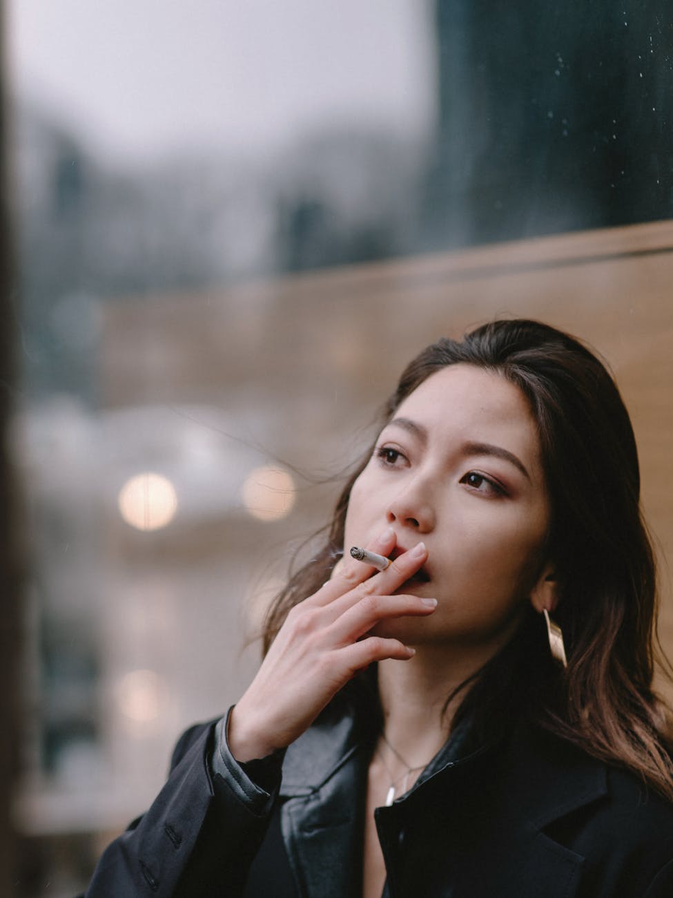 thoughtful young woman smoking cigarette