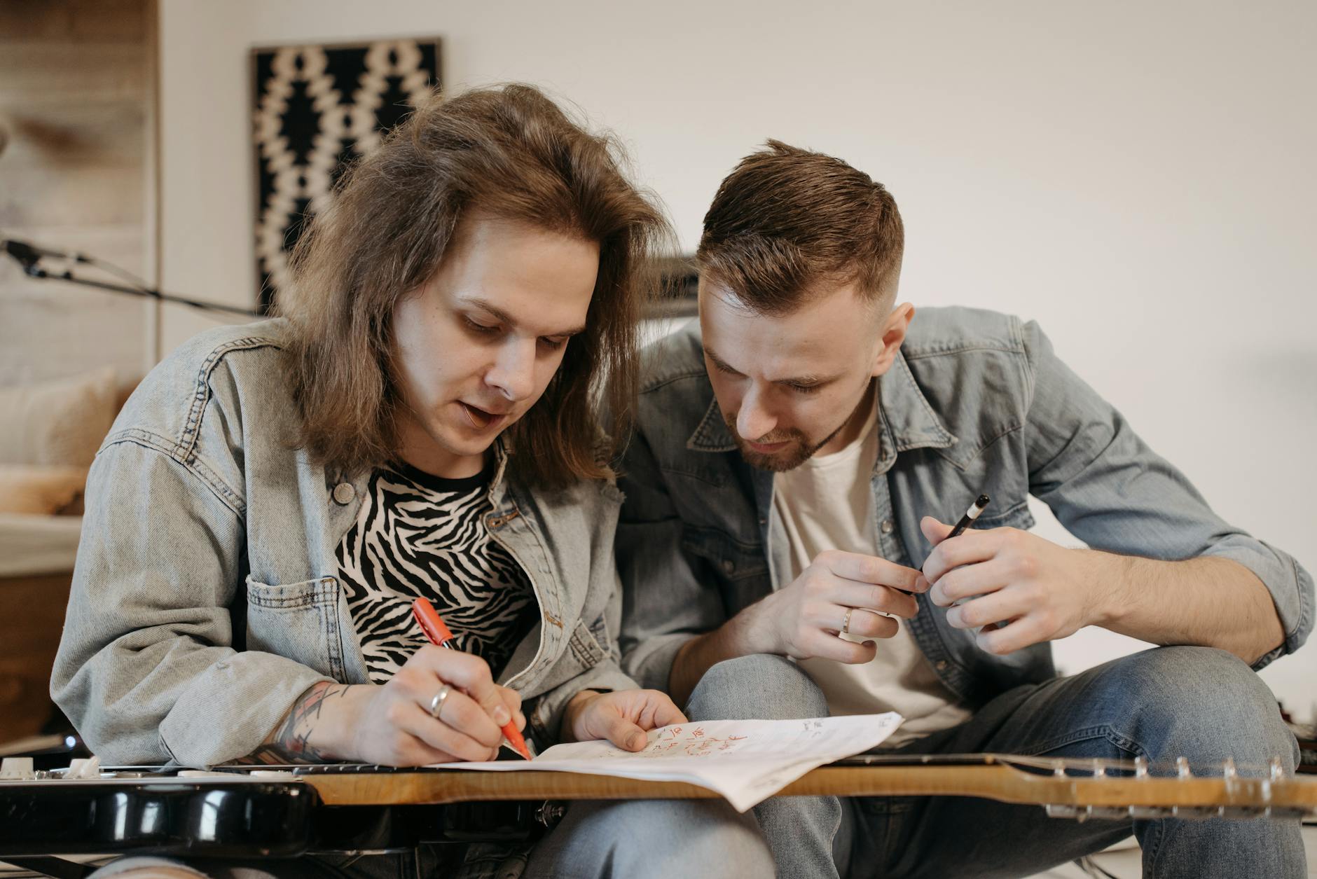 band members in denim jackets composing music