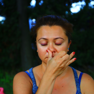 "Vrouw doet Nadi Shodhana ademhalingsoefening, waarbij ze afwisselend door elk neusgat ademt voor balans en ontspanning."